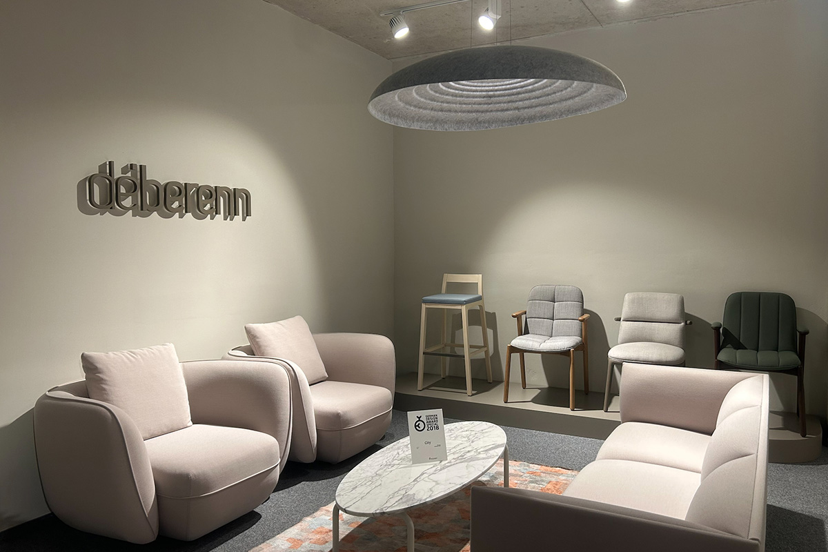 Moderner Lounge-Bereich im deberenn Showroom in München mit eleganten Sesseln, einem Marmorcouchtisch und Designleuchten.